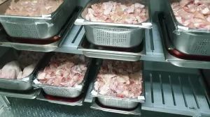 Frozen poultry being defrosted in a dedicated thawing chiller in an industrial kitchen